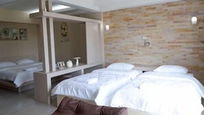 A hotel room with two beds, a large mirror, a white console table, and a stone-patterned wall. - Shi-ro-i Poshtel (Hat Yai)