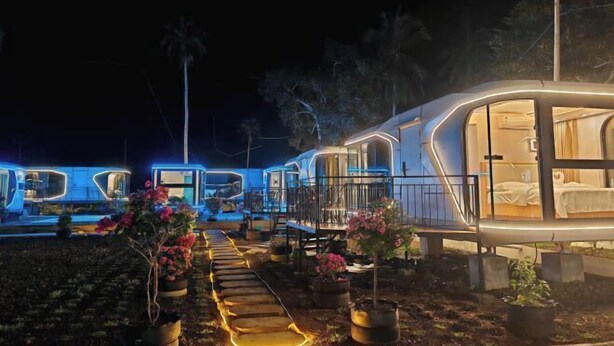 A series of modern, well-lit mobile homes with a pathway leading to a bedroom area. - Seawind Garden (Semporna)