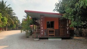 A small, single-story building with a red roof and a 'WELCOME' sign.
