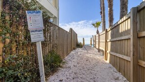 Ein sandiger Pfad führt zu einem Holzzaun, an dem ein Schild den Strandzugang nur für Eigentümer und Mieter ausweist.