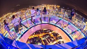 Eine runde Glasplattform mit weitem Panoramablick über die Stadt.
