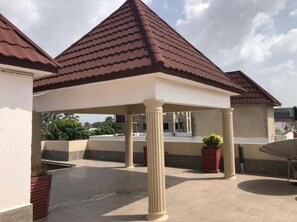 A covered outdoor area with a tiled roof, columns, and potted plants. - Charming villa with AC in Bijilo - Perfect for a relaxing getaway (Bijilo)