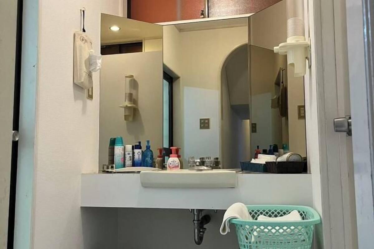 A bathroom with a sink, mirror, and various toiletries.