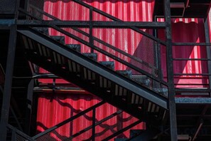 A metal staircase with a red background. - Semporna Seaview Hotel (Semporna)