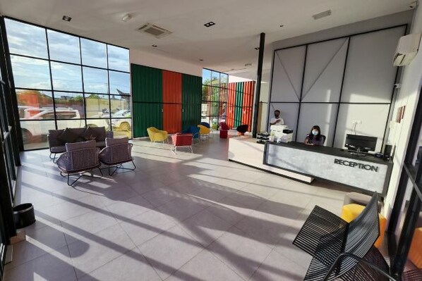 Un área de recepción con mostrador, asientos y ventanas amplias.