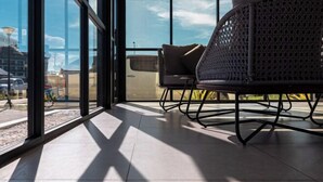 A modern interior with a large window, a wicker chair, and a sofa. - Semporna Seaview Hotel (Semporna)
