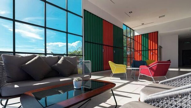 A modern lounge area with a sofa, chairs, and a glass coffee table. - Semporna Seaview Hotel (Semporna)