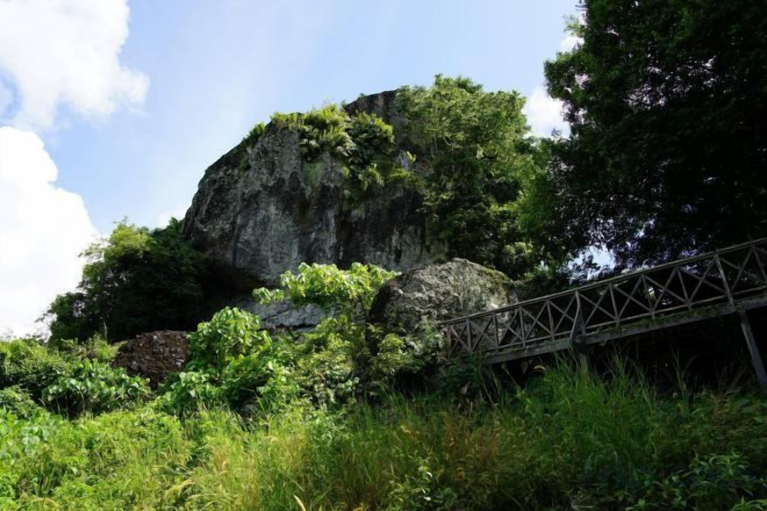Une formation rocheuse naturelle surmontée d’un pont métallique.