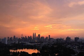 Ein Stadtpanorama im Abendlicht mit einem Wasserflächen im Vordergrund.