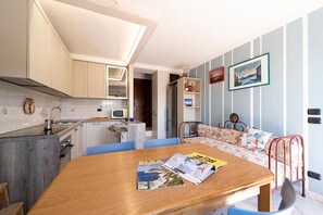 A compact living space with a kitchen, dining area, and a small seating area with a sofa and a bed.