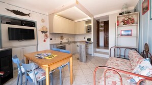 Un espace de vie compact comprenant un coin repas, une kitchenette et un canapé.