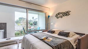 A modern bedroom with a large bed, a balcony with a view, and a unique wall art piece. - Apartment Le Zal by Interhome (Quiberon)