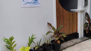 A building with a sign reading "Swims Maldives" and a wooden fence. - swims maldives (Omadhoo)
