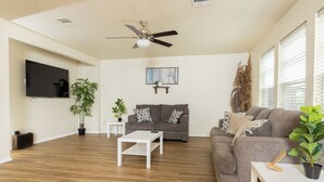 A spacious living room with a grey sofa, white coffee table, and a ceiling fan. - This home is minutes away from:
SEA WORLD
FIESTA TEXAS
RIVERWALK
4 JOINT BASES + (San Antonio)