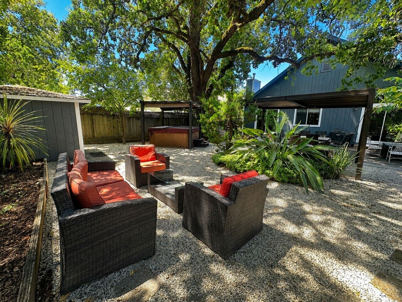 A patio area with wicker furniture, a barbecue grill, and a covered seating area.