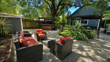 A patio area with wicker furniture, a barbecue grill, and a covered seating area.