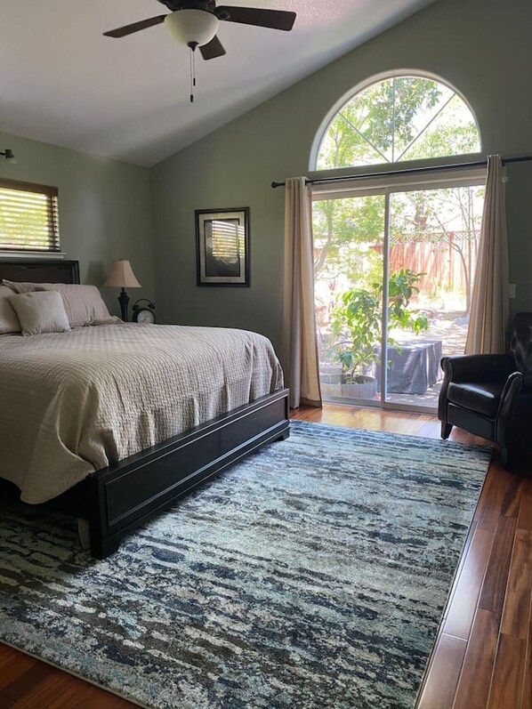 Quarto com cama, ventilador de teto, janela e vista para o exterior.