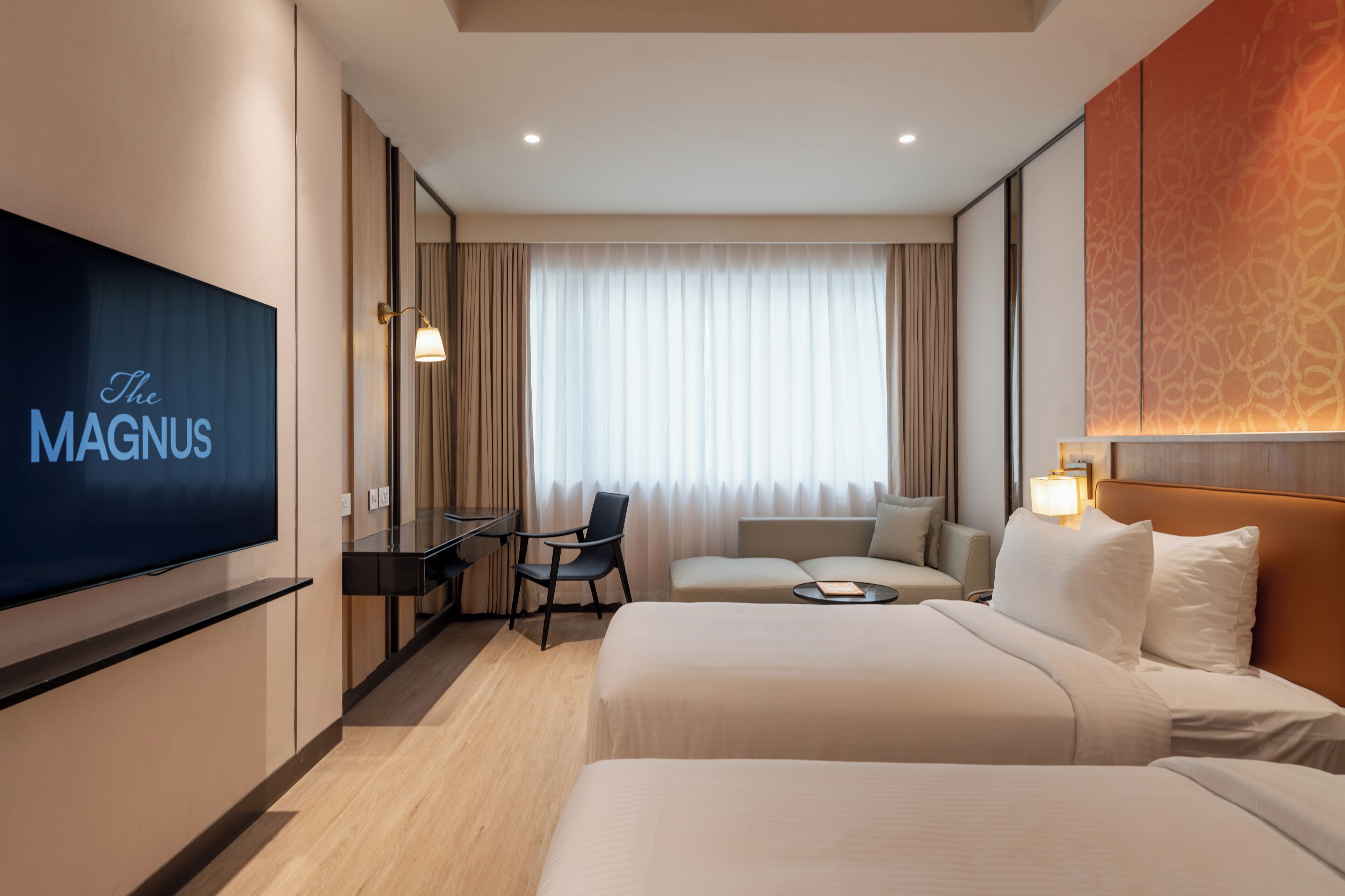 A hotel room with a bed, a desk, a chair, a television, and a large window with curtains.