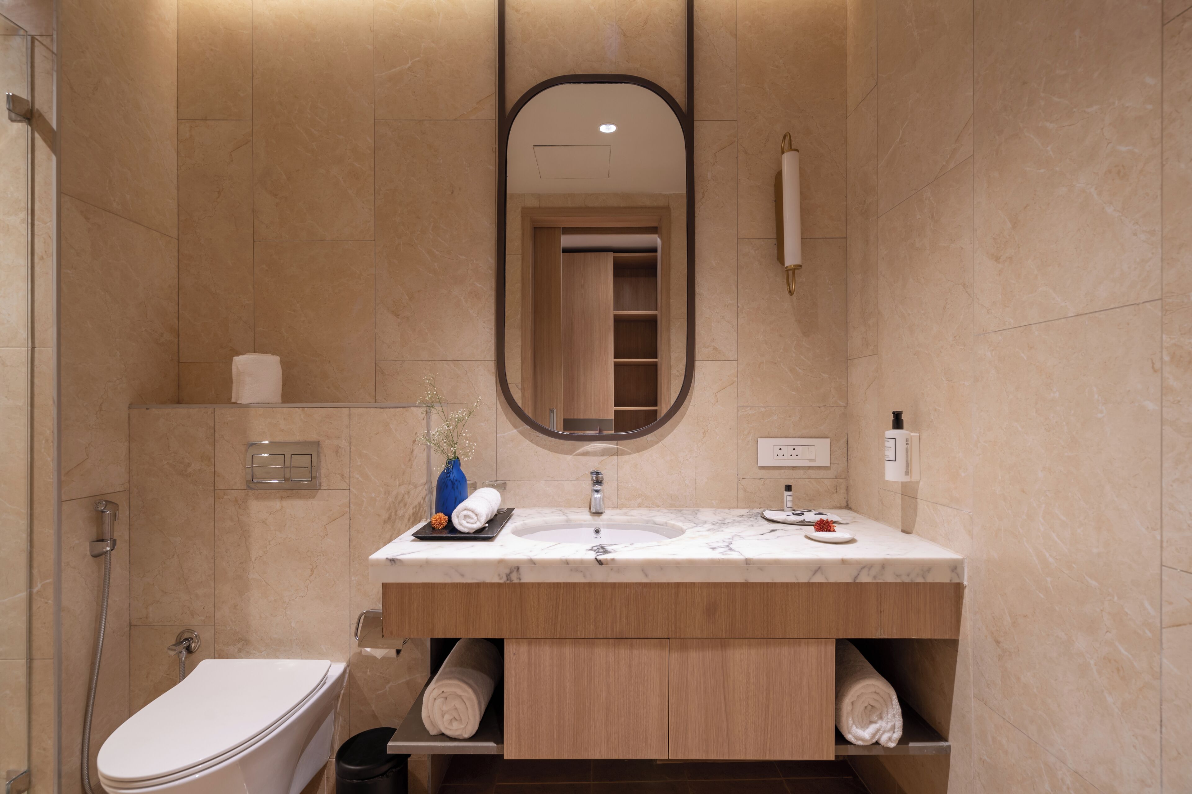 A modern bathroom with a toilet, sink, and mirror.