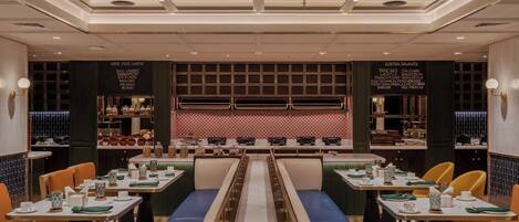 A restaurant with a central counter, booths, and a patterned floor.