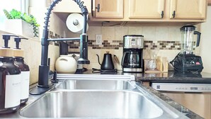 A kitchen with a stainless steel sink, a coffee maker, a blender, and a kettle. - Seaside Sanctuary - Rooftop Deck & Hot Tub (Hermosa Beach)
