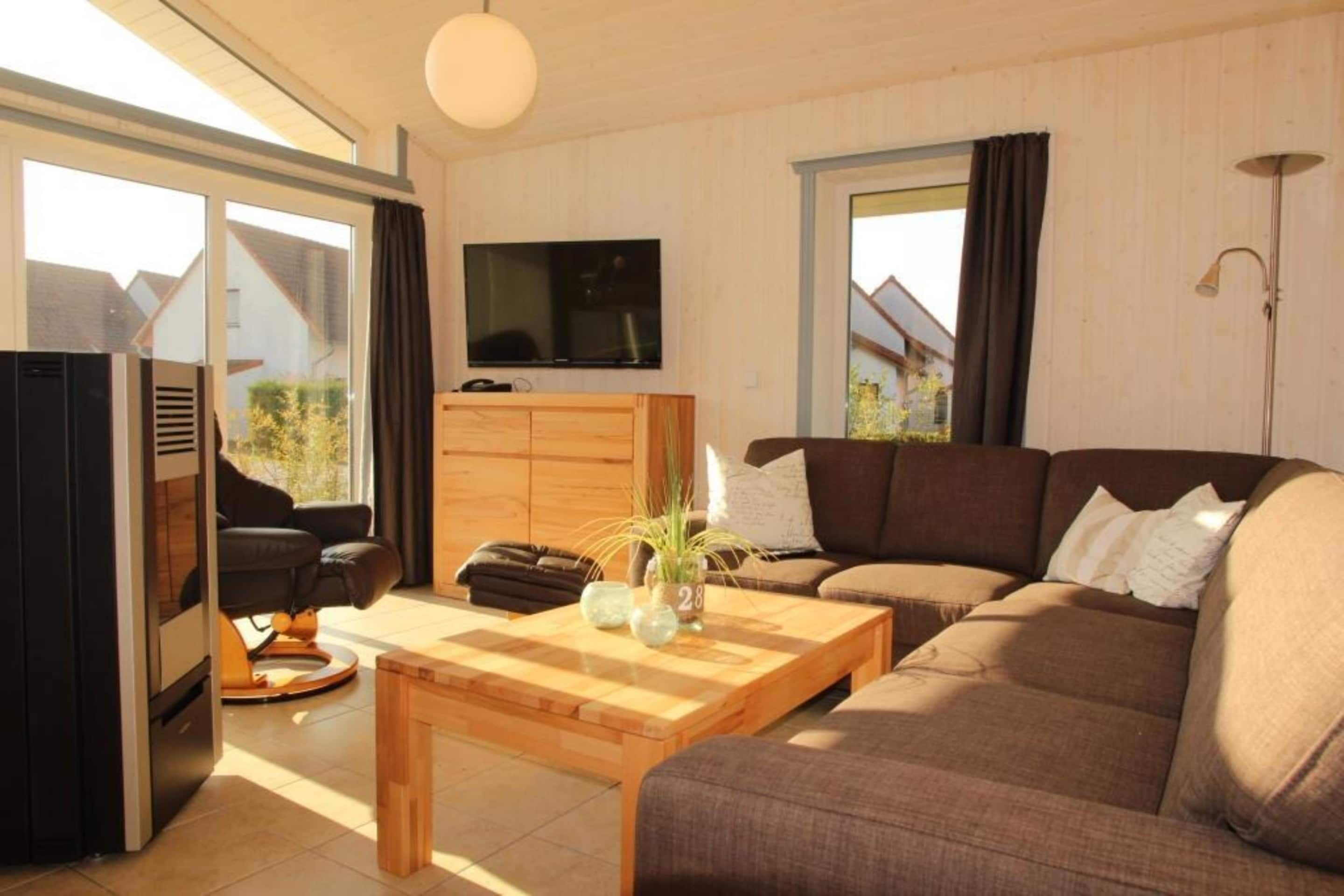 A modern living room with a sofa, a coffee table, a TV, and a sliding door leading to a balcony.