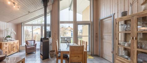 A spacious room with a large dining table, wooden cabinets, and a fireplace.