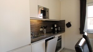 A compact kitchen with a microwave, coffee maker, and oven. - Doppelhaushalfte in Burhave (Butjadingen)