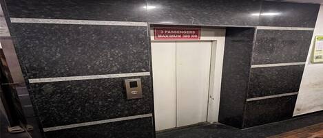An elevator with a sign indicating a maximum weight limit of 380 kg for 3 passengers.