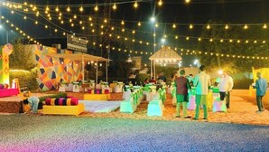 An outdoor event with a stage, tents, and string lights. - Hotel Clay Inn (Sohna)