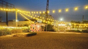 A building with a colorful facade and a small structure with a roof. - Hotel Clay Inn (Sohna)