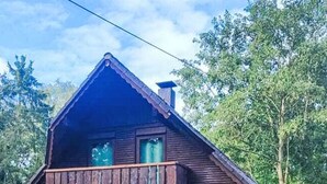 A two-story house with a balcony, a patio with outdoor furniture, and a fenced yard. - Tim´s Alm am Silbersee by Interhome (Frielendorf)