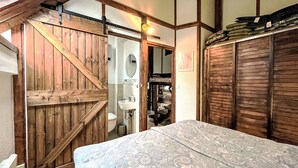 A bedroom with a wooden door, a bed with a patterned bedspread, and a wardrobe. - Tim´s Alm am Silbersee by Interhome (Frielendorf)