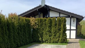 A house with a paved driveway, a satellite dish, and a mailbox marked with the number 49. - Freistehender Ferienbungalow im Fachwerkstil (Butjadingen)