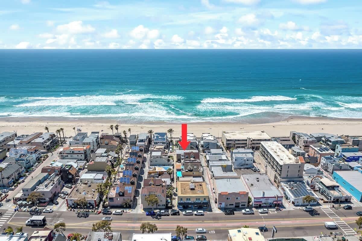 Une vue aérienne d’une ville côtière, avec ses bâtiments, ses rues et sa plage.