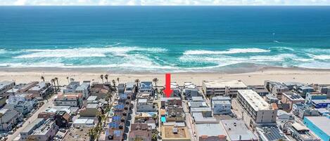 Une vue aérienne d’une ville côtière, avec ses bâtiments, ses rues et sa plage.