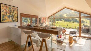 Een moderne keuken met een groot raam, een eethoek en uitzicht op het platteland.