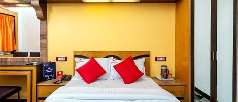 A hotel room with a bed, two nightstands, a desk, and a wardrobe.
