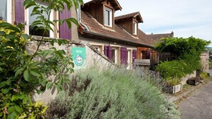 Un bâtiment rustique avec une façade en pierre, des volets en bois et une enseigne indiquant qu’il s’agit d’un gîte.
