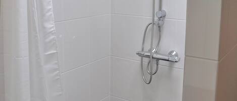 Eine Dusche mit Handbrause, fest installierter Duschköpfe und einem zusätzlichen Handduschteil.