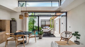 A modern interior with a dining area, a pool, and a lounge area. - Blue Kai Villa by Alfred in Bali (Pecatu)