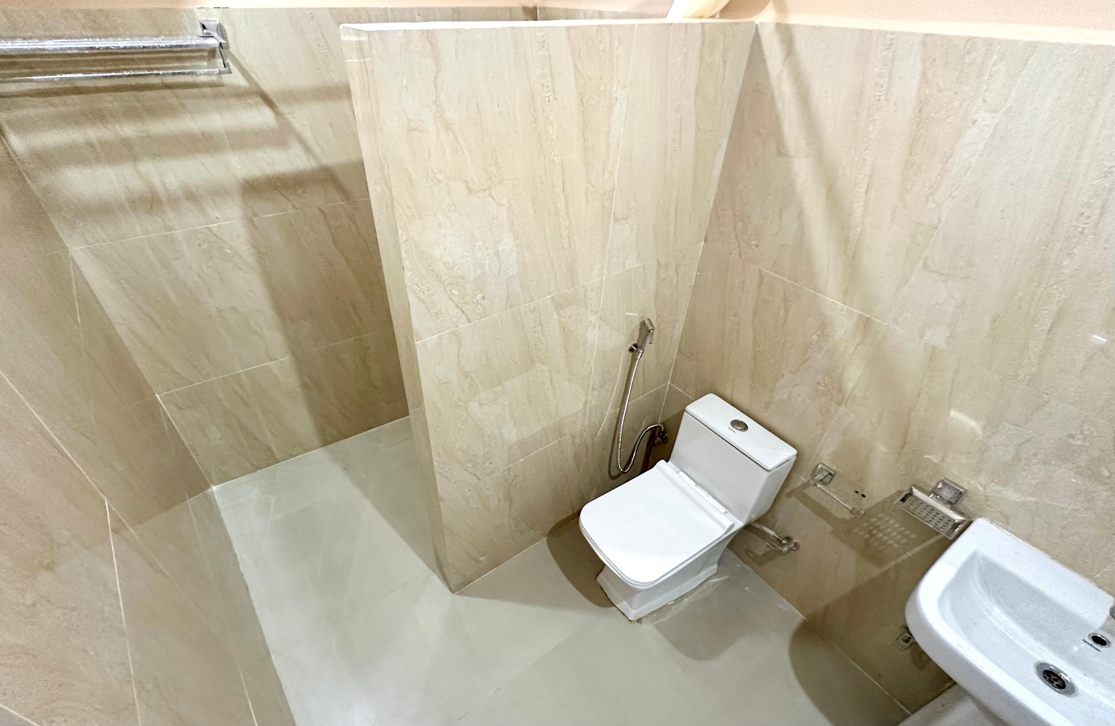 Une salle de bain avec douche, toilettes et lavabo.