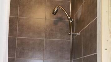 A shower with a handheld showerhead and a fixed wall-mounted showerhead.