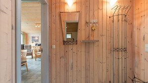 A wooden interior with a mirror, a 'HOME' sign, and a coat rack. - Ferienhaus mit Sauna im Ferienpark Mirow (Mirow)