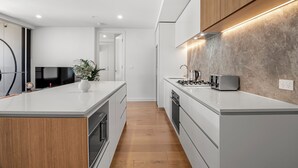 Una cocina moderna con una isla central, armarios de madera y un horno empotrado.
