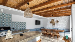 Une cuisine moderne avec un plan de travail en pierre, des chaises en bois et une table à manger.