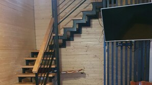 Un interno in legno con una scala, una sedia e un tavolino.