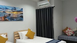 A hotel room with two beds, a painting of a sunset, an air conditioner, and a curtain. - Hug Udon (Udon Thani)