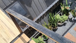 A rooftop garden with potted plants and a wooden deck. - Hug Udon (Udon Thani)