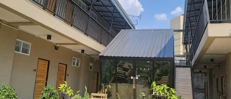 A residential building with a covered outdoor area, a staircase, and a small garden.